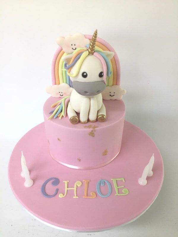 pink cake with unicorn and rainbow topper